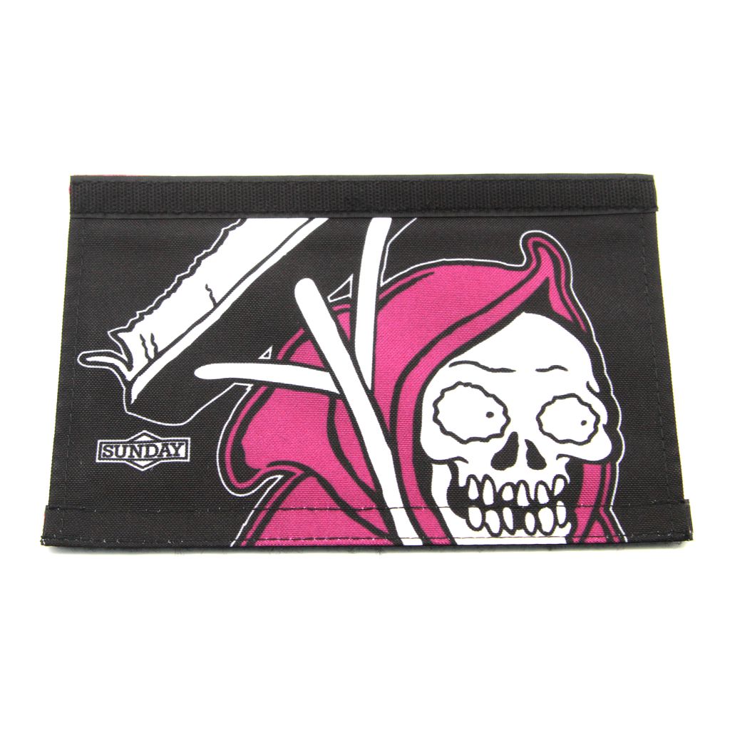 The Sunday Wallflower V2 Reversible Handlebar Pad is black with a design featuring a cartoon Grim Reaper in a red hood. The logo "SUNDAY" is printed in the bottom left corner, and it features a convenient Velcro closure.