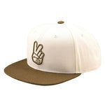 The TLD 25.1 Peace Hat radiates a classic style with its beige color, brown brim, and an embroidered peace sign hand on the front.