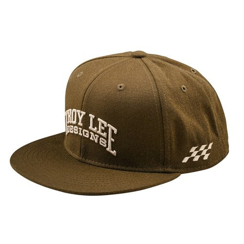 The TLD 25.1 Scholar Hat is a brown flat-brim baseball cap displaying "Troy Lee Designs" on the front and a checkered flag on the side, offering a sophisticated style for fashion enthusiasts.