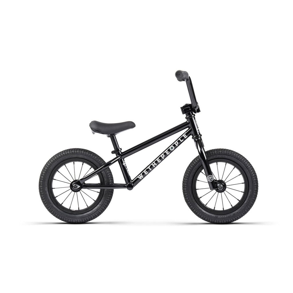 The Wethepeople Prime Balance BMX Bike is a sleek black balance bike with two wheels, handlebars, and a small seat, ideal for young riders ready to start their BMX journey.