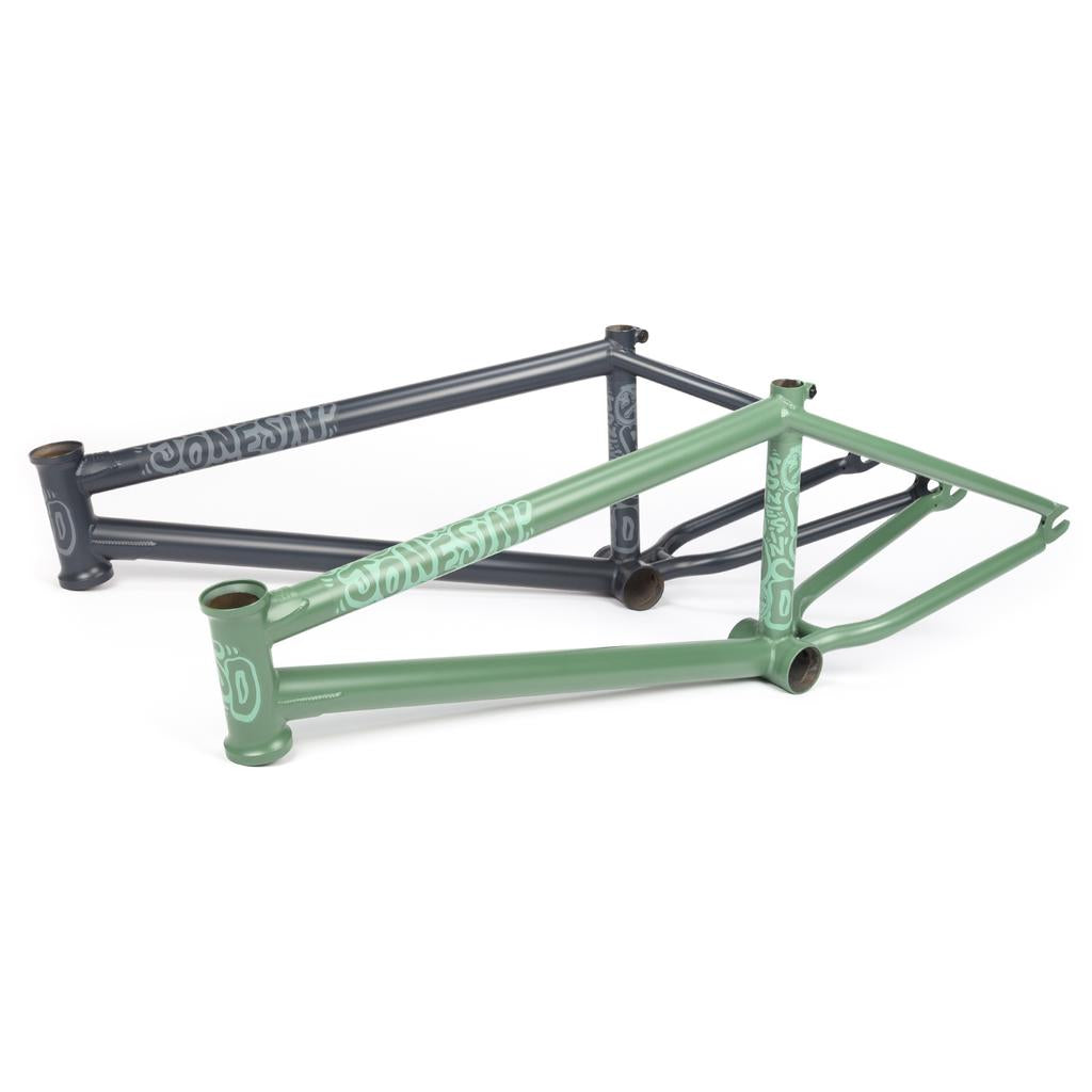 Two bicycle frames with modern street geometry, one dark gray and the other green, are side by side. Both showcase branding text and geometric designs, reflecting the sleek style reminiscent of the 2021 BSD Jonesin Frame's innovation.