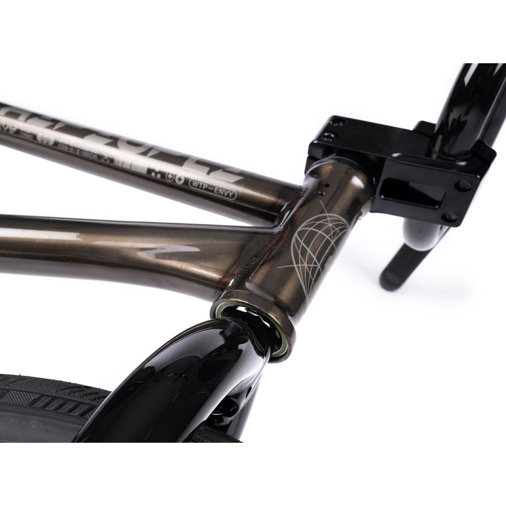 Close-up of a Wethepeople Envy 20 Inch BMX Bike frame highlighting the matte gray head tube and top tube with black details. The black front fork and part of the front wheel are visible, emphasizing the BMX bike's sleek design.