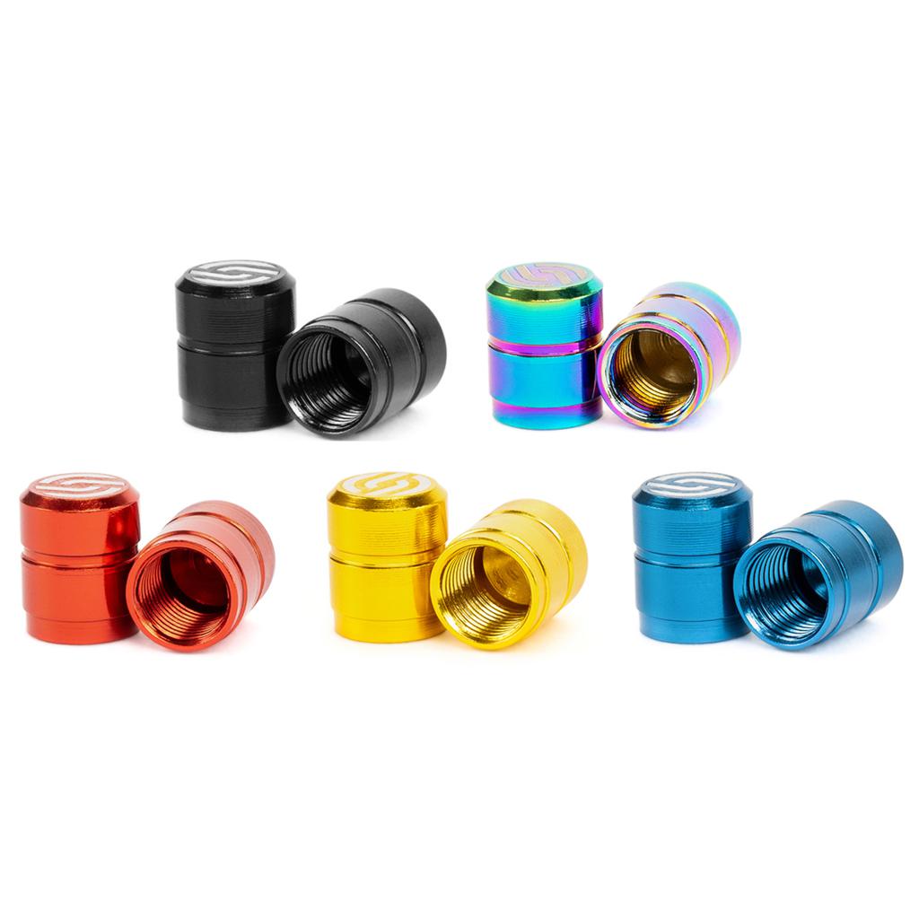 Five pairs of Salt CNC Valve Caps, crafted from durable 6061-T6 alloy, are displayed in metallic shades of black, red, yellow, blue, and multicolored finishes. Each cap features a sleek design with full CNC precision.