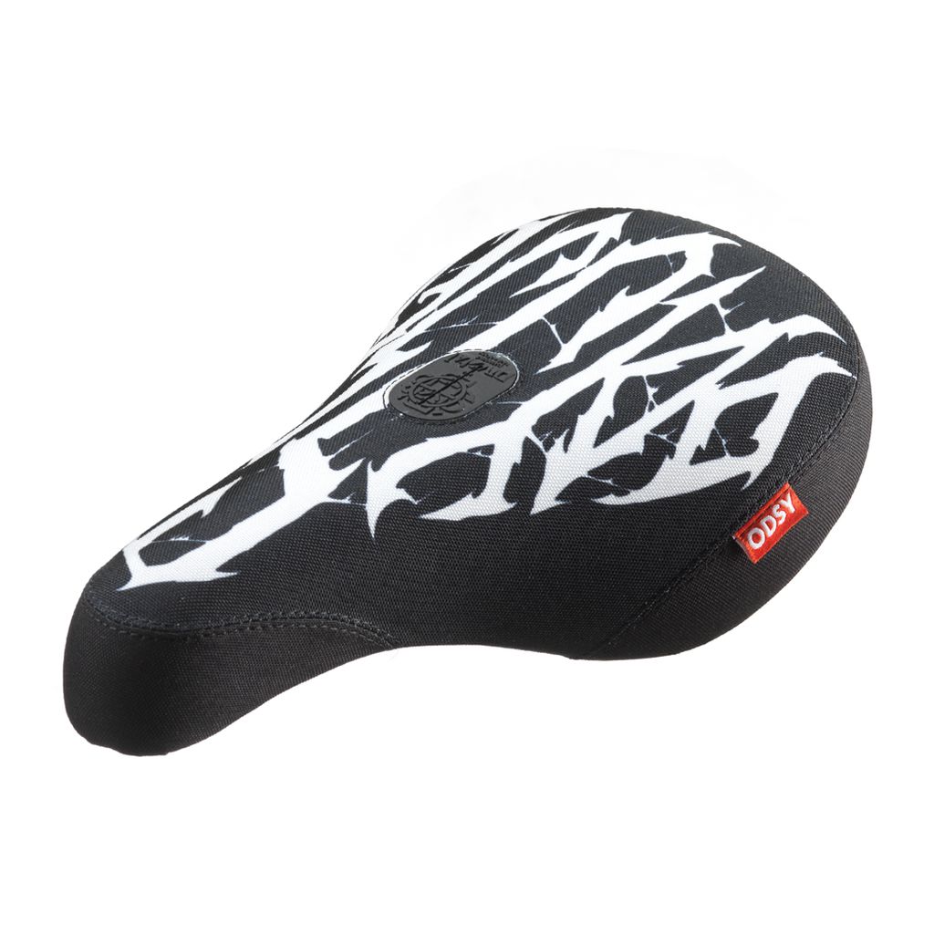 The Odyssey IG Hot Seat is a black bike seat featuring white graffiti-style patterns and a red "ODSY" tag on the side. This Pivotal Fat design is perfect for those looking to stand out.