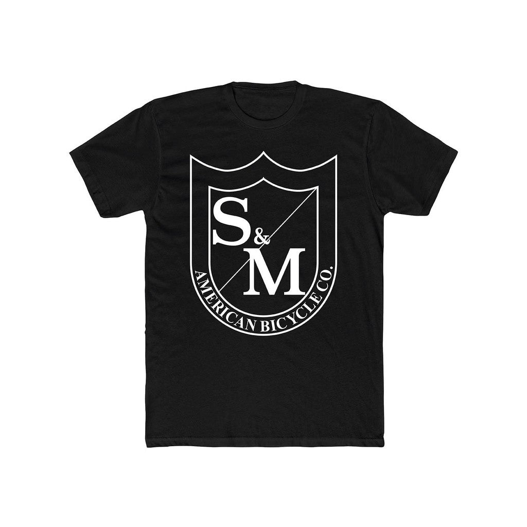 The S & M Big Shield T-Shirt is a black shirt featuring an oversized front print of the S&M American Bicycle Co. logo with stylized "S & M" letters in white. It is crafted from 100% combed ring-spun cotton, ensuring excellent comfort and durability.