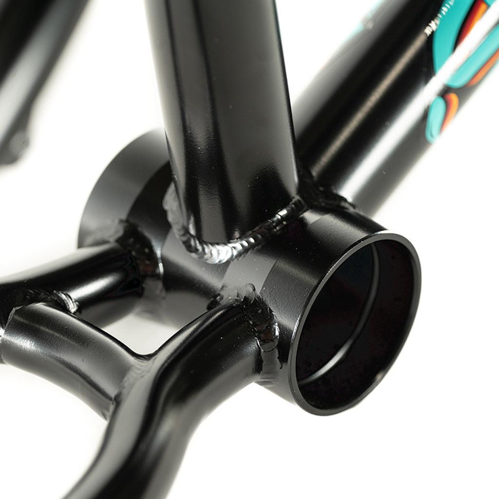 A close up of a black Colony 2024 Sweet Tooth 16 Inch BMX bicycle frame with a colorful handlebar.