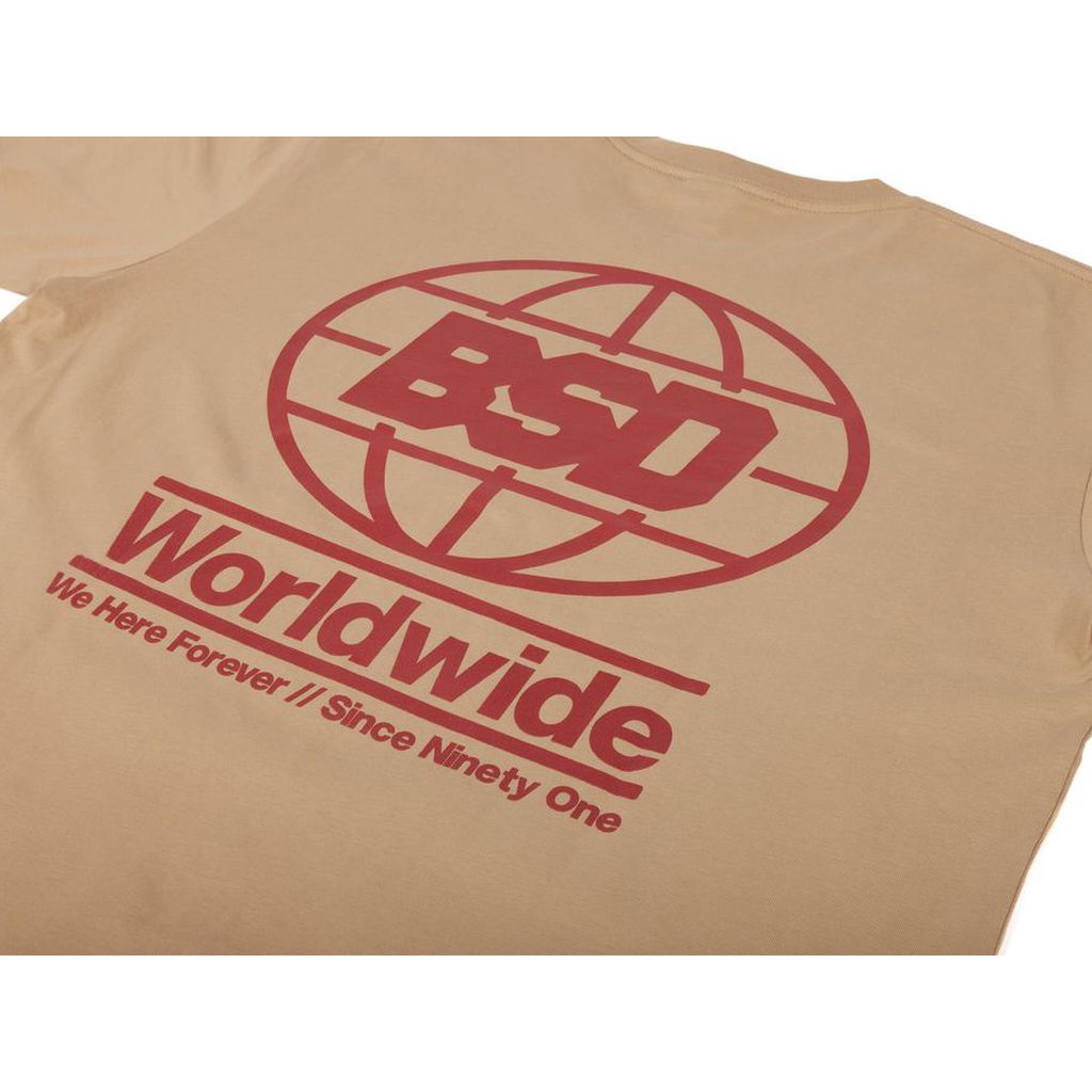 A BSD We Here Forever Tee with red text and a globe logo. The shirt reads "BSD Worldwide" and "We Here Forever / Since Ninety One.