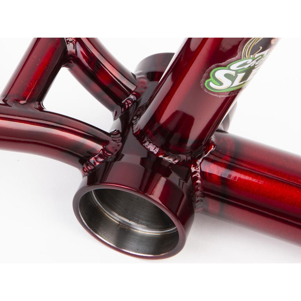 A close-up of a glossy red Fit Bike Co Sleeper (Ethan Corriere) Frame joint showcases detailed welding and a circular opening, ideal for street BMX enthusiasts seeking precision and flair.