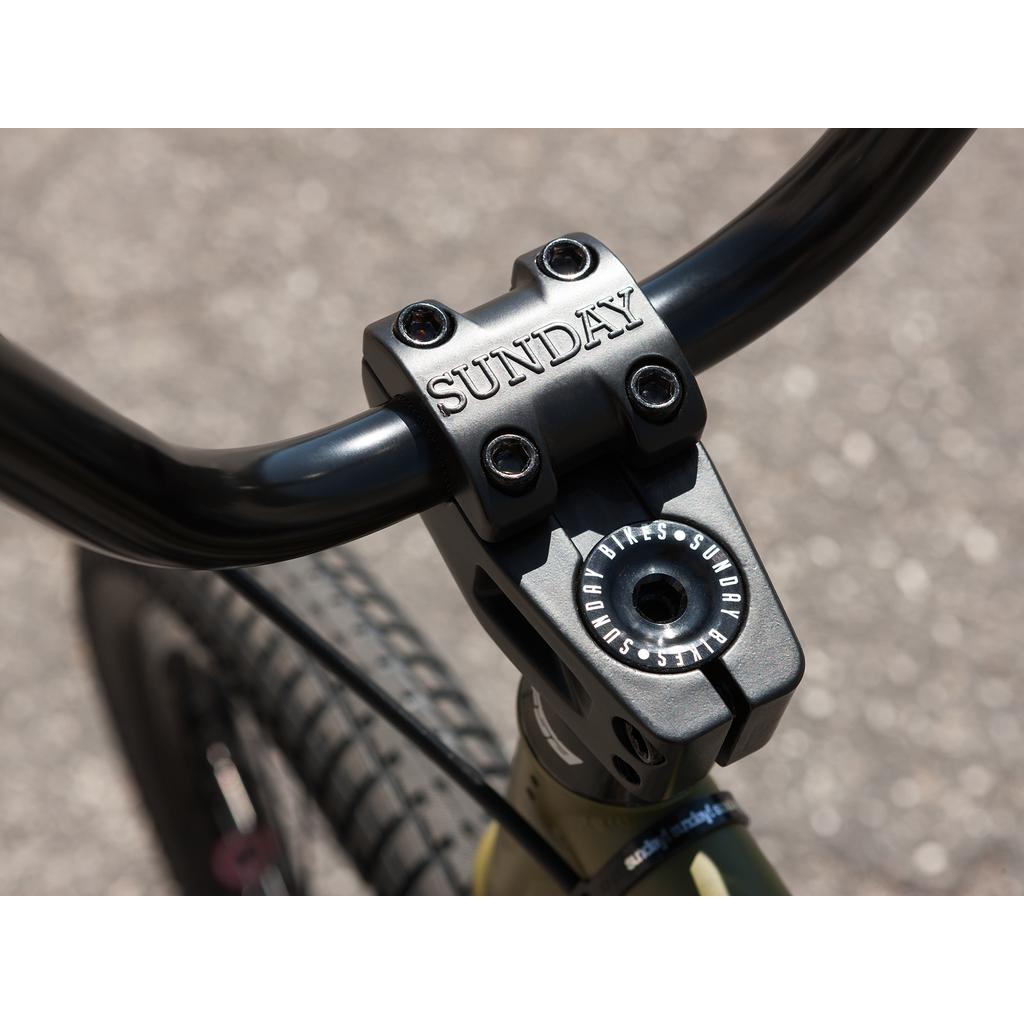 Close-up of the "Sunday" branded handlebar stem on a bike, reflecting the innovative craftsmanship found in Odyssey parts and the Sunday Wave Length 20 Inch (Gary Young) series.