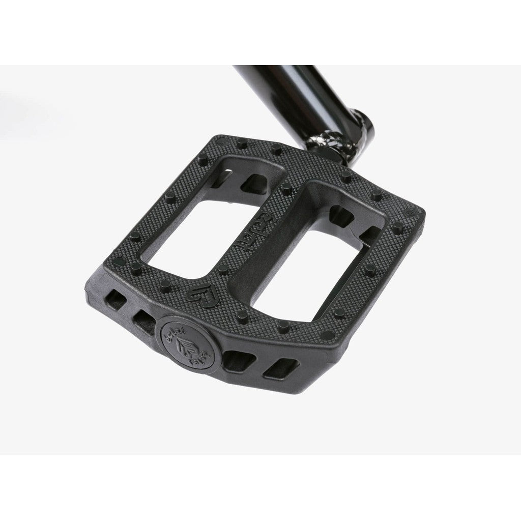 Close-up of a black bicycle pedal with a textured surface and metal pins, attached to a crank arm from the Wethepeople CRS FS 18 Inch BMX Bike, on a white background.