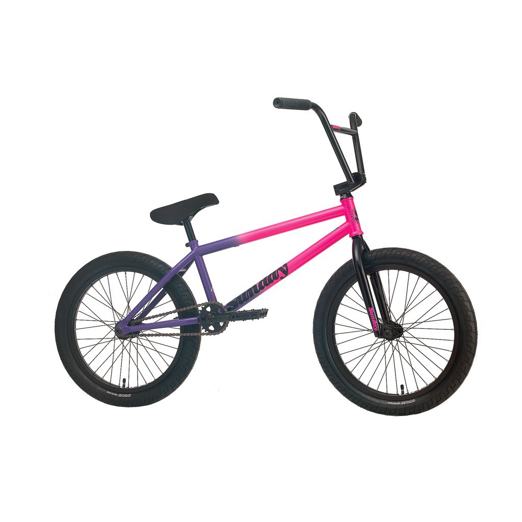 A Sunday Street Sweeper 20 Inch Bike showcasing a stylish gradient pink and purple chromoly frame, paired with black handlebars and wheels, all presented against a contrasting white background.