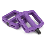 The Cinema Tilt Pedals in purple possess a textured surface and traction pins, crafted for superior grip. They are each fastened with a single bolt attachment to ensure ease and stability.