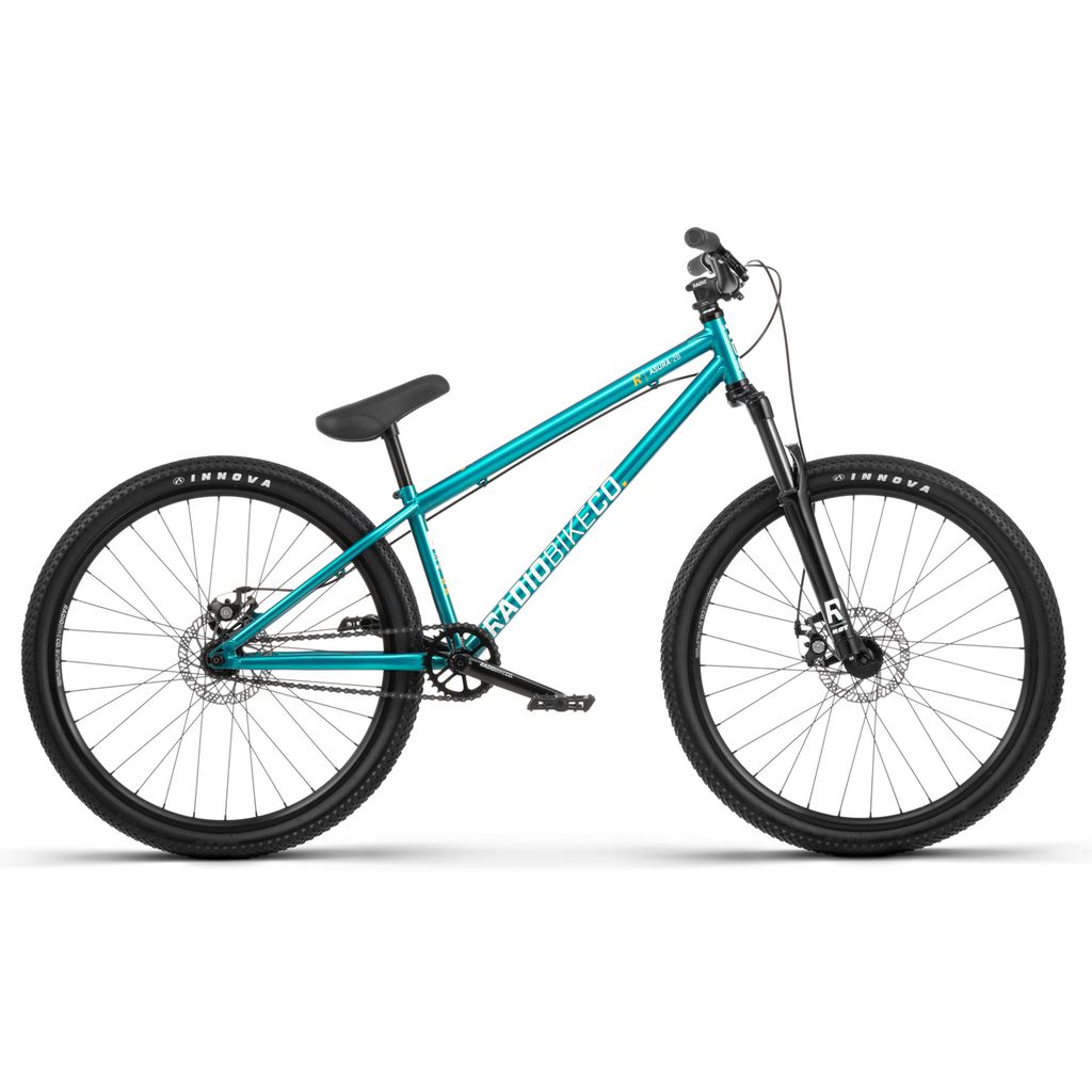 The Radio 26 Inch Asura Bike boasts a turquoise color with black handlebars, seat, and wheels. It features a robust chromoly steel frame and a front suspension fork, equipped with thick all-terrain tires ideal for off-road biking.