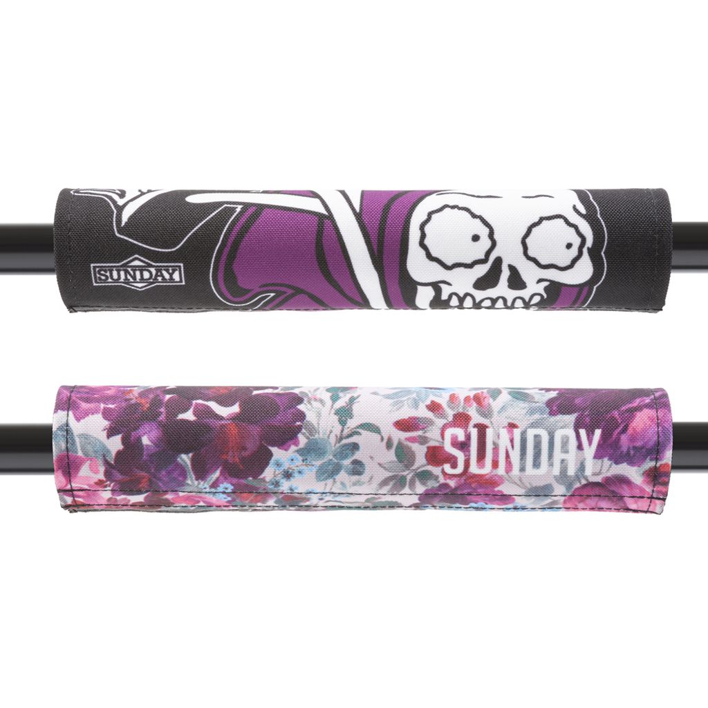 The Sunday Wallflower V2 Reversible Handlebar Pad features two stylish designs, one with a skull graphic and the other with a floral pattern. This branded handlebar pad is equipped with Velcro closures for easy attachment, offering versatile 2-in-1 style options.