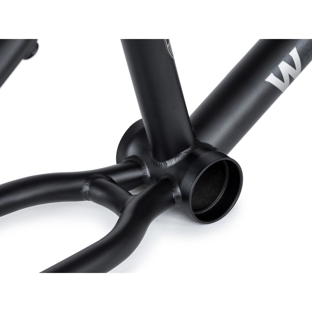 Close-up of the bottom bracket area of the Wethepeople Audio 22 Inch Frame/Fork Kit, showcasing the perfectly connected chromoly chain stays and seat stays on the sleek black BMX frame.