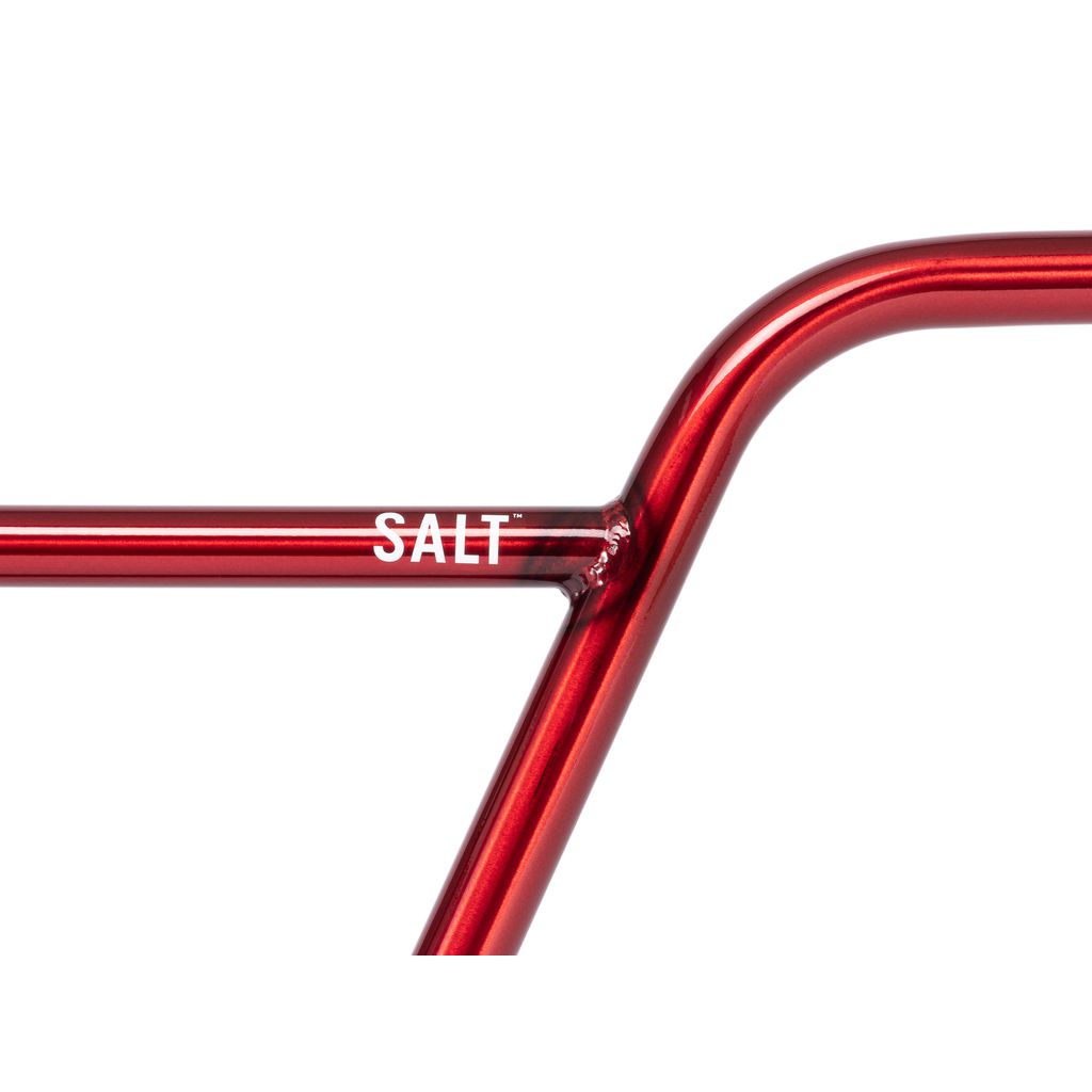 A close-up of a red bicycle frame with "SALT" printed in white, showcasing the Salt Pro Bars for an added touch of performance and style.