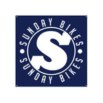 The Sunday S Logo Banner features a blue square design with a prominent large white "S" at its center, surrounded by the brand name. It's an ideal piece for BMX enthusiasts with its weather-resistant quality.