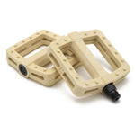 Two Cinema Tilt Pedals in beige, both rectangular with a textured surface and equipped with traction pins for improved grip, are placed so that they overlap each other.