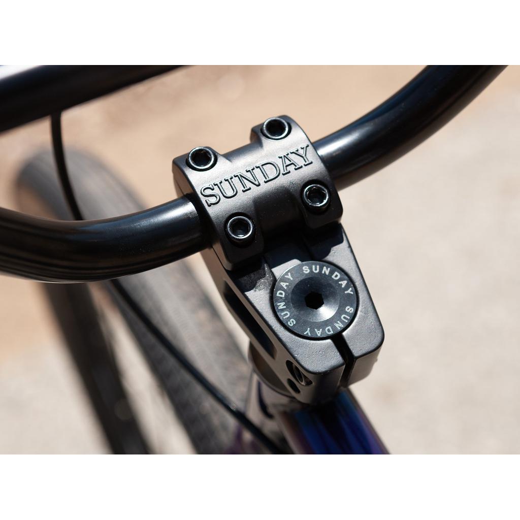 A close-up of the handlebar stem embossed with "Sunday" highlights the precision and craftsmanship of the Sunday High C 29 Inch Bike.