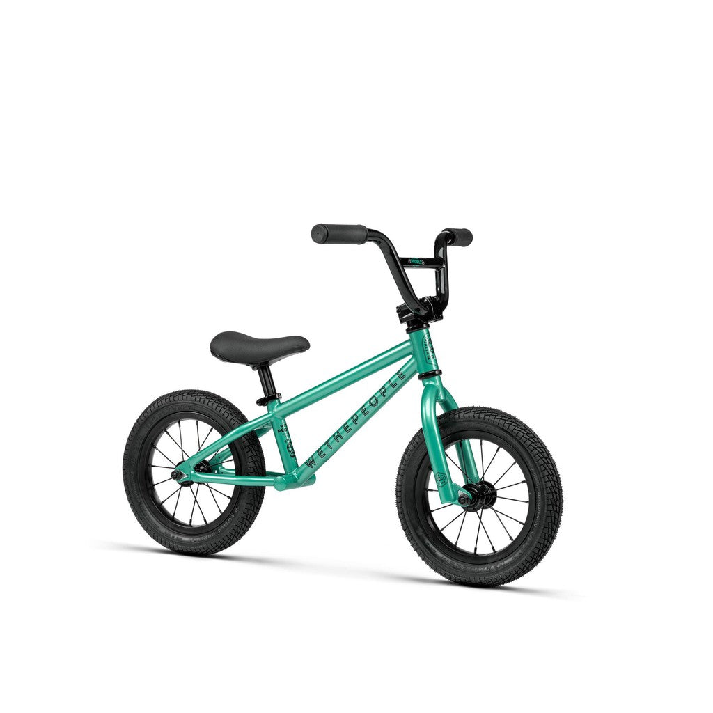 The Wethepeople Prime Balance BMX Bike has a turquoise frame with black handlebars and wheels, ideal for young children learning to ride.