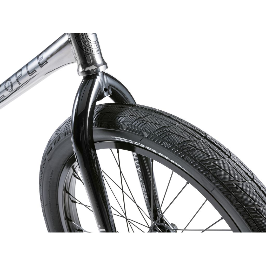 Close-up of the Wethepeople Envy 20 Inch BMX Bike's front fork and tire, highlighting the BMX masterpiece's tread pattern and metal spokes against a white background.