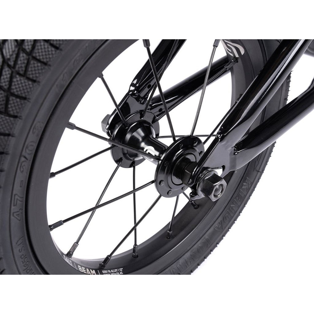 Close-up of a wheel from the Wethepeople Prime Balance BMX Bike, featuring black spokes, a central hub, and a thick tire on a white background.