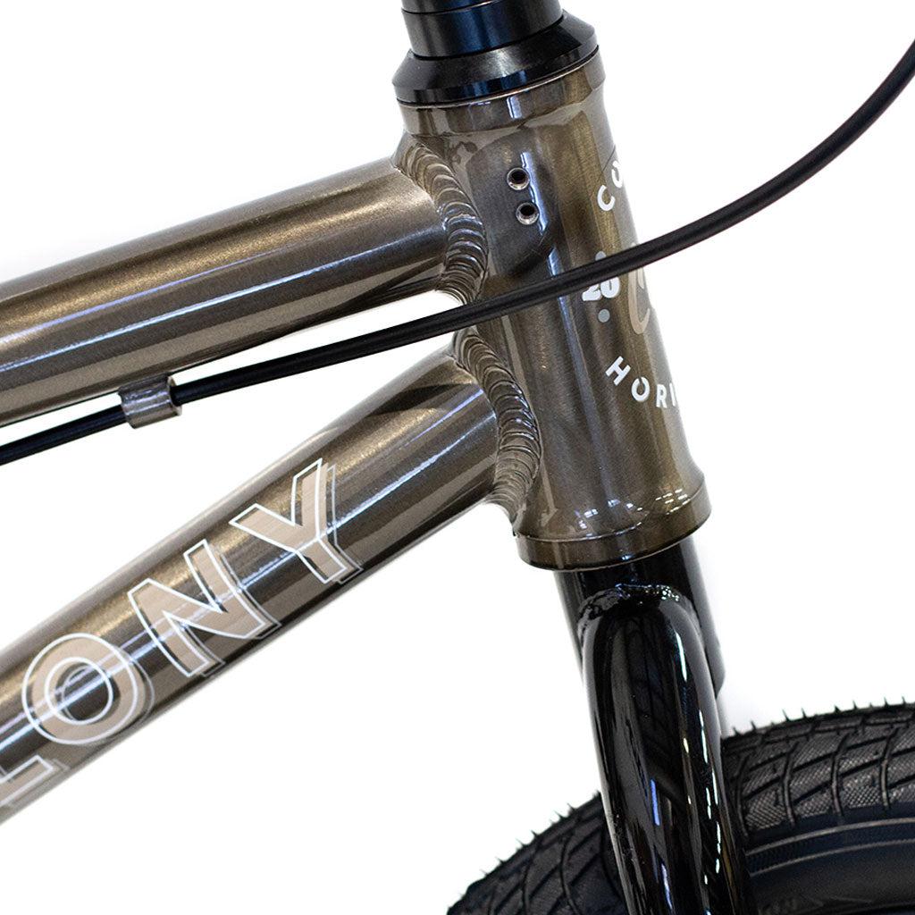 Close-up of a Colony Horizon 12 Inch Bike frame with the word "COLONY" and visible welding, showcasing its lightweight alloy frame along with part of the front tire and handlebars.