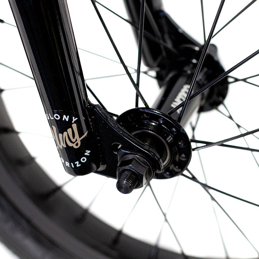 Close-up of the Colony Horizon 14 Inch Bike's front wheel hub and spokes, showcasing a black fork with branding, emphasizing the sleek design often favored by Olympic athletes for its lightweight alloy frame.