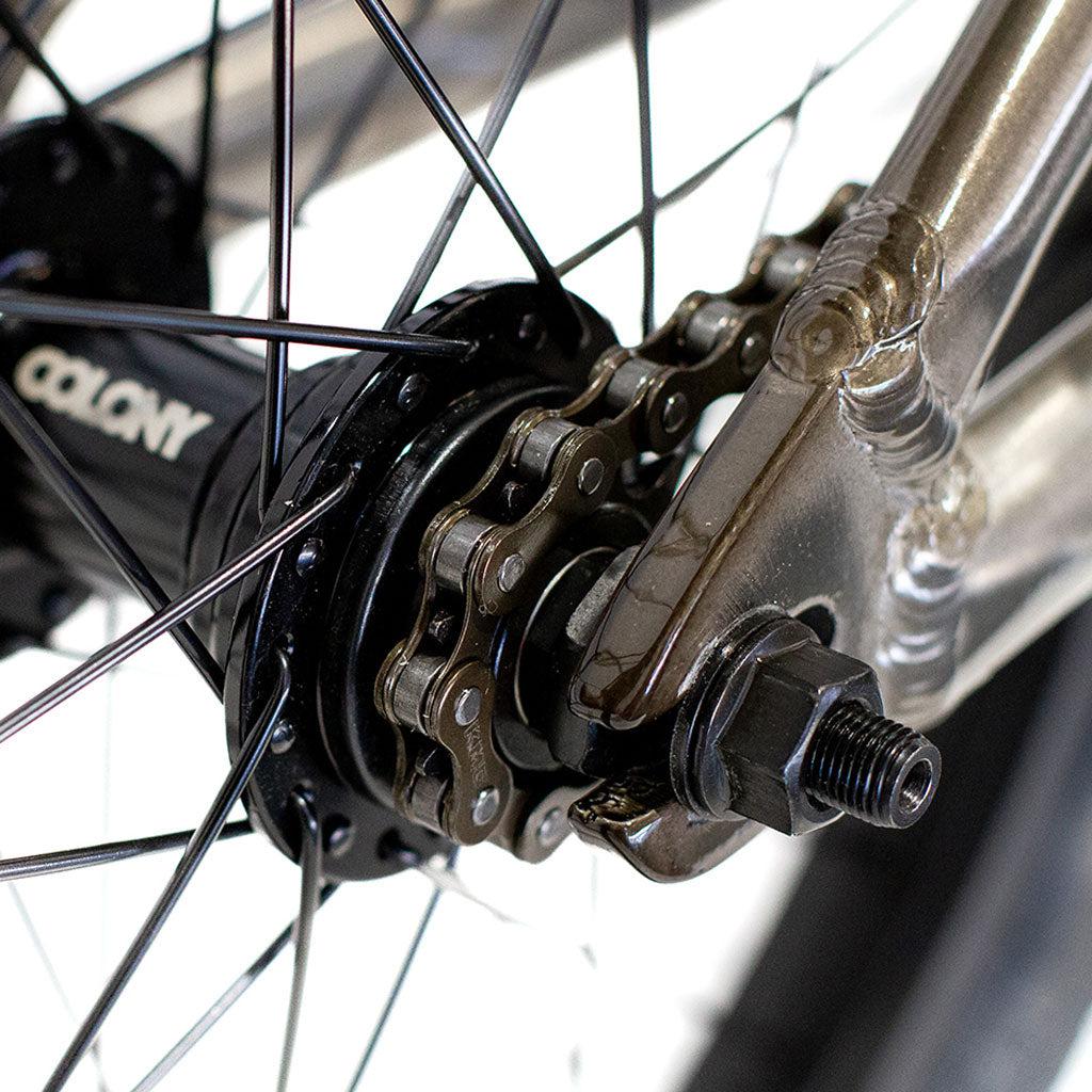 Close-up image of the Colony Horizon 20 Inch Freestyle Bike's rear wheel hub and chain mechanism, showcasing a detailed view of the sprockets, axle, and spokes with Colony branding visible on the hub. The precise engineering makes this setup ideal for any freestyle Olympic athlete aiming for peak performance.