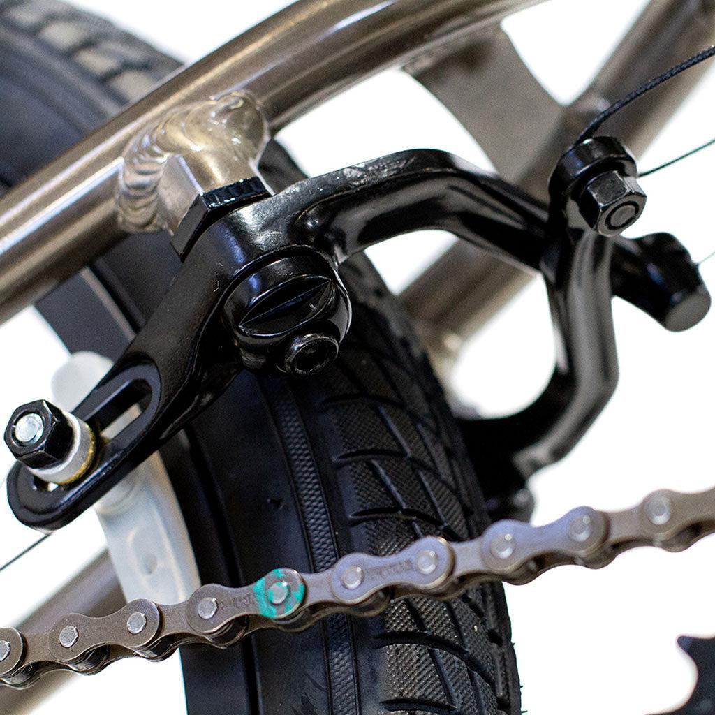 Close-up of a Colony Horizon 20 Inch Freestyle Bike brake mechanism, showcasing the tire, brake caliper, and part of the chain.