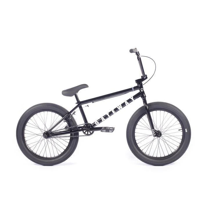 The Cult Gateway 20 Inch Bike, sporting a sleek black design, comes equipped with thick tires, a padded seat, and BMX handlebars.