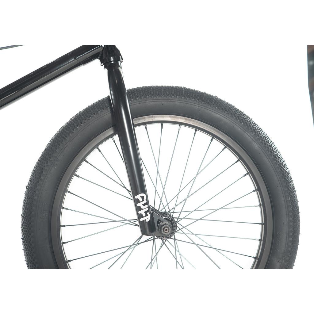 Close-up of the Cult Gateway 20 Inch Bike's front wheel showcasing a black fork, tire, spokes, and lettering. Its modern geometry combines style and performance, catering to enthusiasts pursuing top-notch cycling adventures.