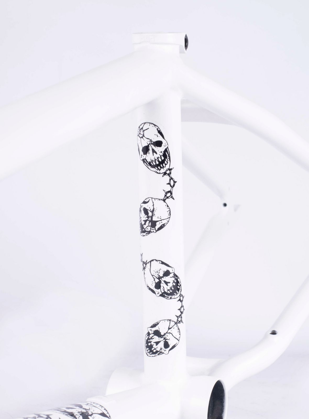 Close-up of the Cult Walsh Frame (Corey Walsh) BMX, highlighting a vertical row of black and white skull designs on its sleek, large structure.