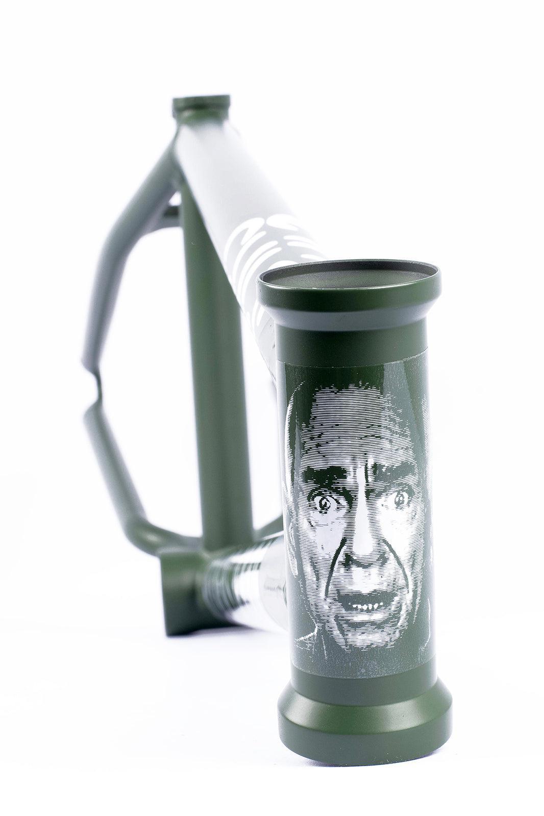 Close-up of a green Cult Heavens Gate Frame (Brandon Begin Signature), featuring a black and white illustration of a man's face on the head tube.