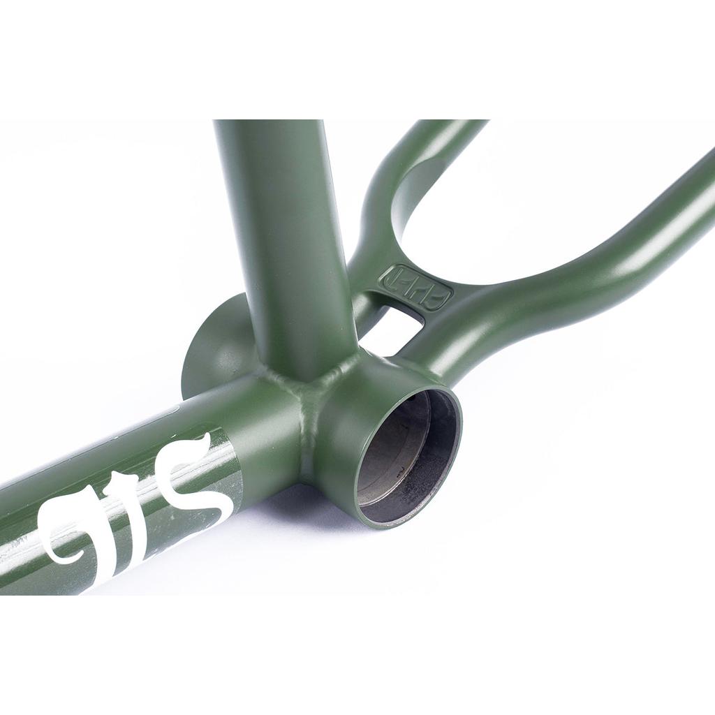 Close-up of a green Cult Heavens Gate (Brandon Begin Signature) Frame highlights its investment cast chainstay yoke and visible bottom bracket. The down tube features partial white lettering, showcasing a sleek design with Cult Classic Tubing.