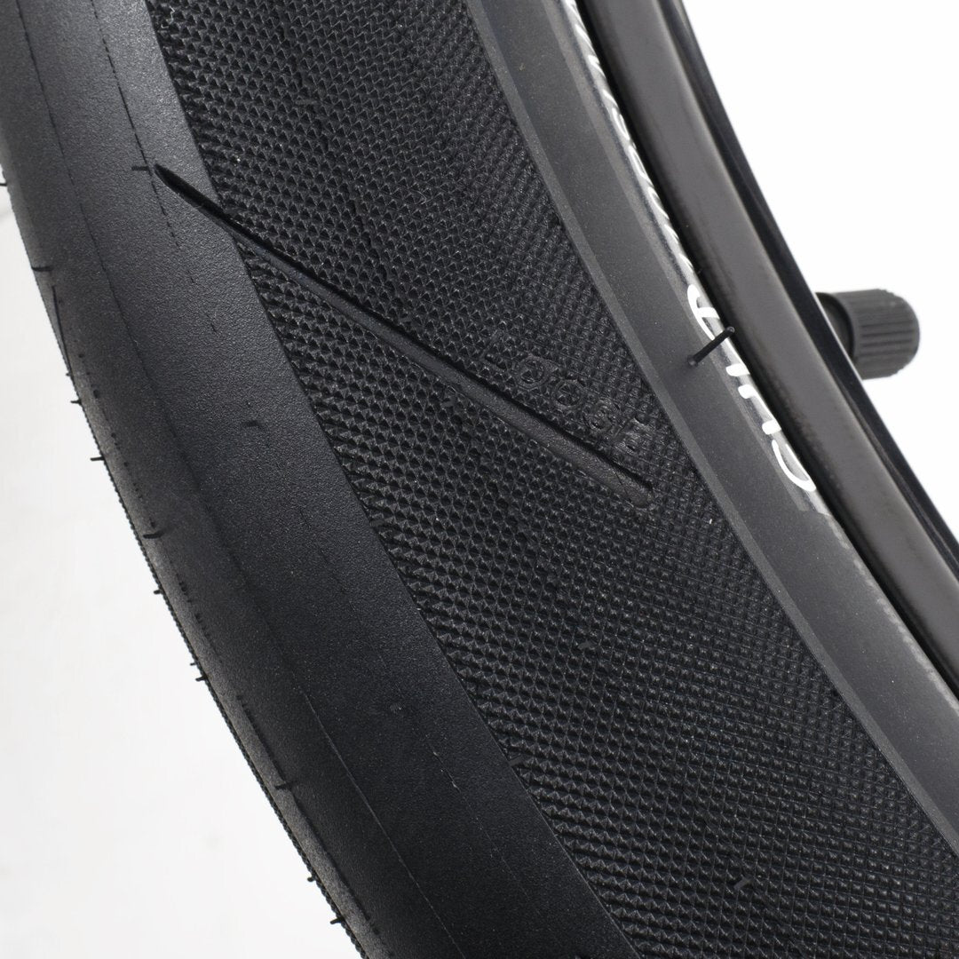 Close-up of a black BMX tire reveals the rugged design of the Cult Fast and Loose Pool Tyre, featuring a thin diagonal cut on the high-pressure sidewall.