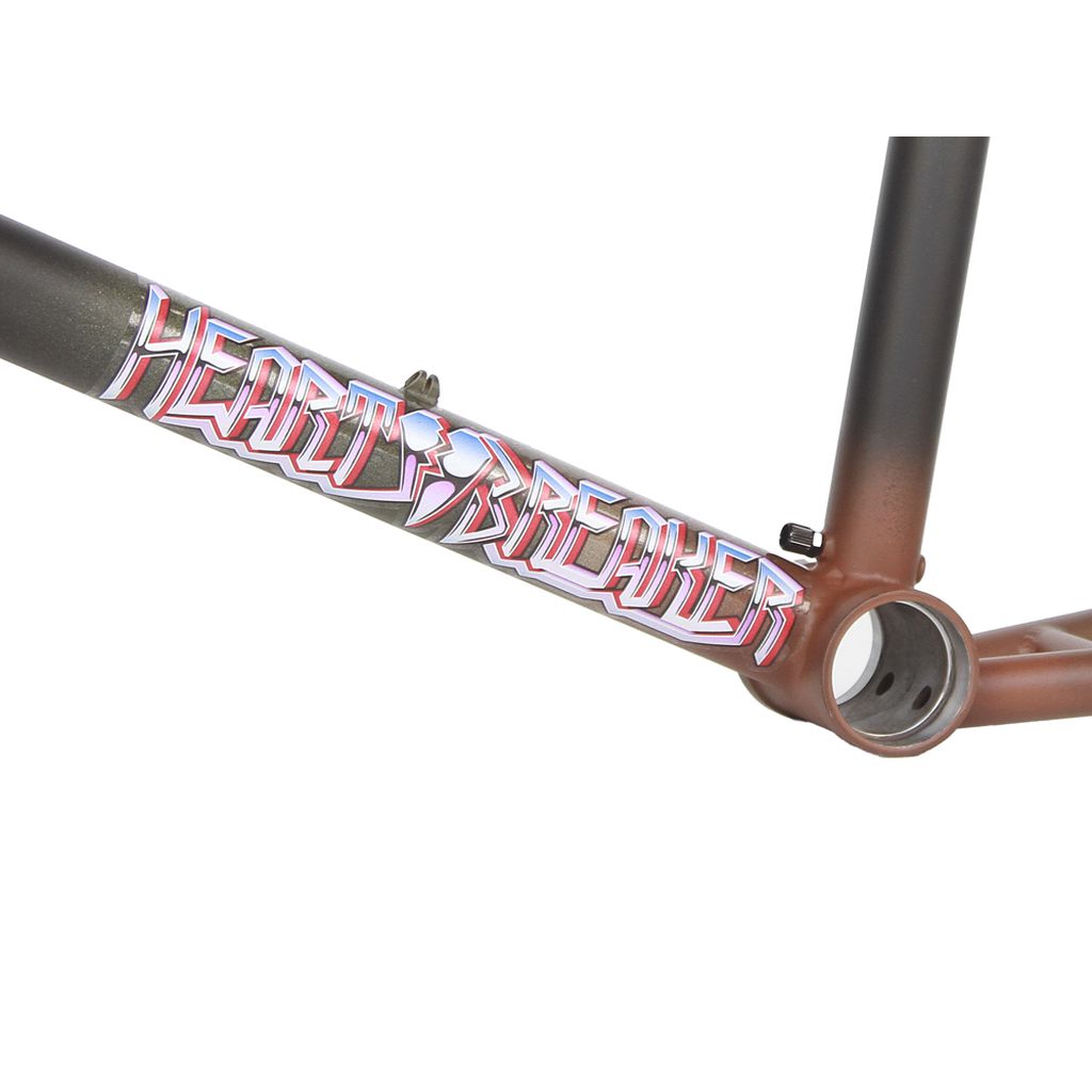 A close-up of the Fit Heartbreaker Frame (Chris Harti) showcases "Heartbreaker" in stylized text on its downtube. This BMX frame features a striking gradient paint job in brown and black, ideal for riders seeking both style and durability.