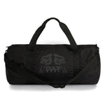 Cult So Sad Duffel Bag is a black cylinder-shaped duffel featuring a crying face design and the word "CULT" on the front. It includes a spacious main compartment, handles, and an adjustable shoulder strap for adaptable use.