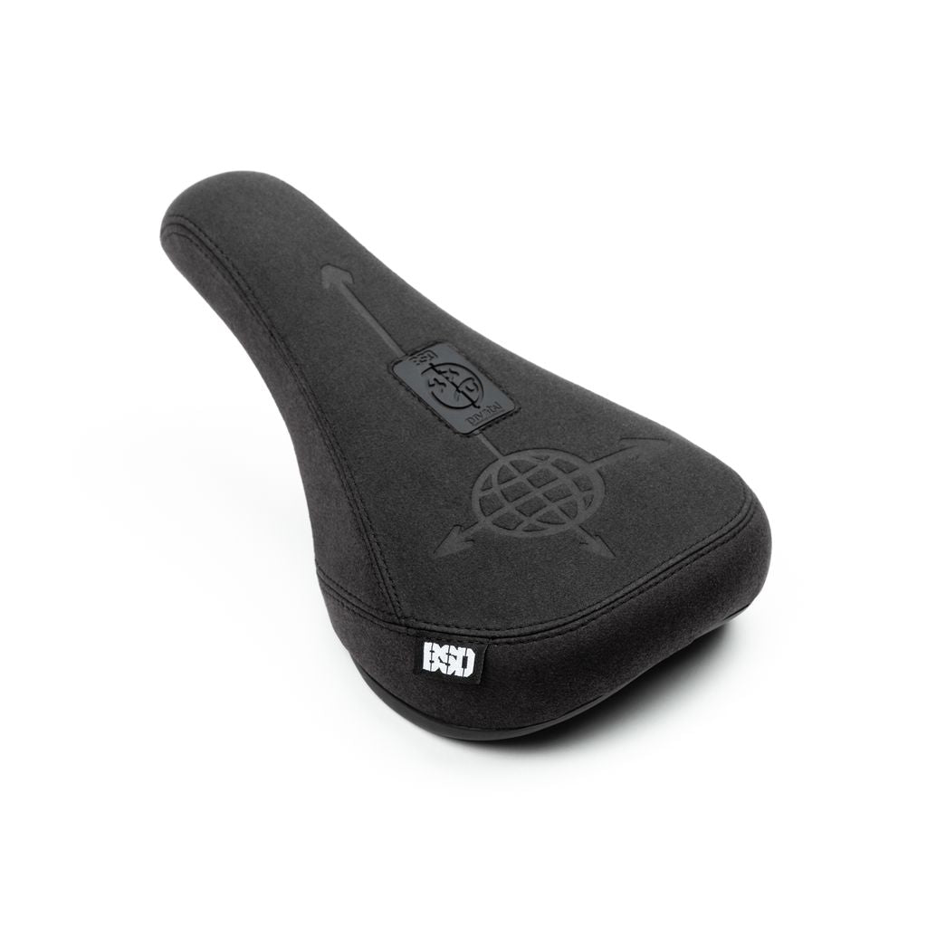 The BSD Freedom Pivotal Slim BMX Seat, a black bicycle saddle with the BSD logo and designs on the top surface, features a sleek black faux suede finish and is shown against a white background.