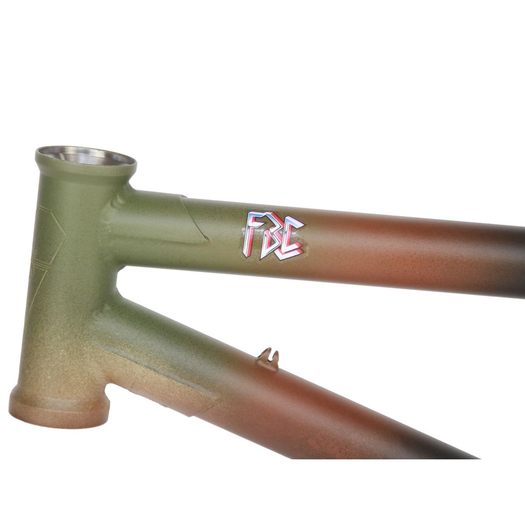 Close-up of a Fit Heartbreaker BMX frame featuring an olive green and brown gradient finish. The side displays a stylish "FBC" logo, showcasing Chris Harti's signature style.