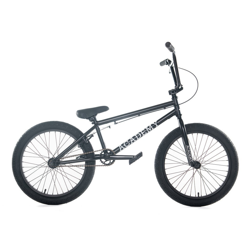 A black Academy Entrant 20 Inch Bike with a straight top tube, sturdy frame, and thick tires is shown against a white background. The bike features a padded seat, handlebars with grips, and foot pegs on both the front and rear wheels—ideal for those seeking entry-level BMX thrills.