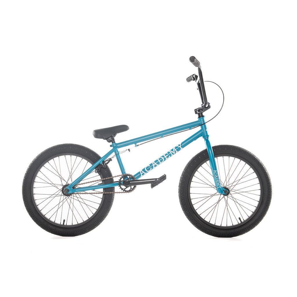 A blue Academy Entrant 20 Inch Bike with black tires and a black seat. The frame displays the brand name "Academy" in white lettering. Perfect for freestyle BMX, the bike is showcased in a side view.