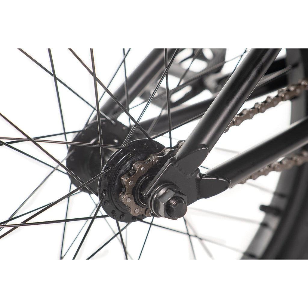 Close-up of the Academy Desire 20 Inch Bike's rear hub, showing spokes, chain, and part of its full Chromoly frame. The image focuses on the mechanical components and connections.