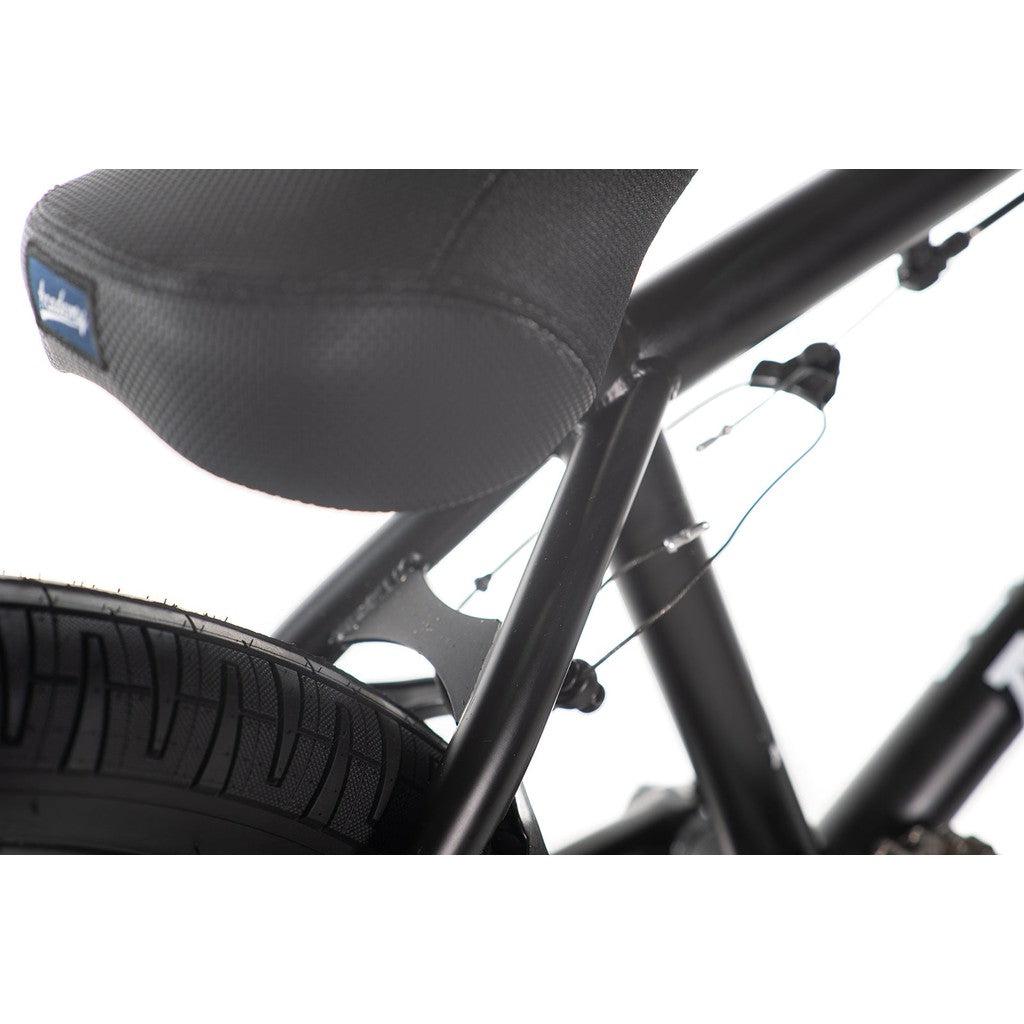 Close-up of the Academy Aspire 20 Inch Bike showcasing a freestyle BMX design with a black bicycle seat, rear tire, and part of the frame with visible brake cables, equipped with sealed hubs for smooth performance.