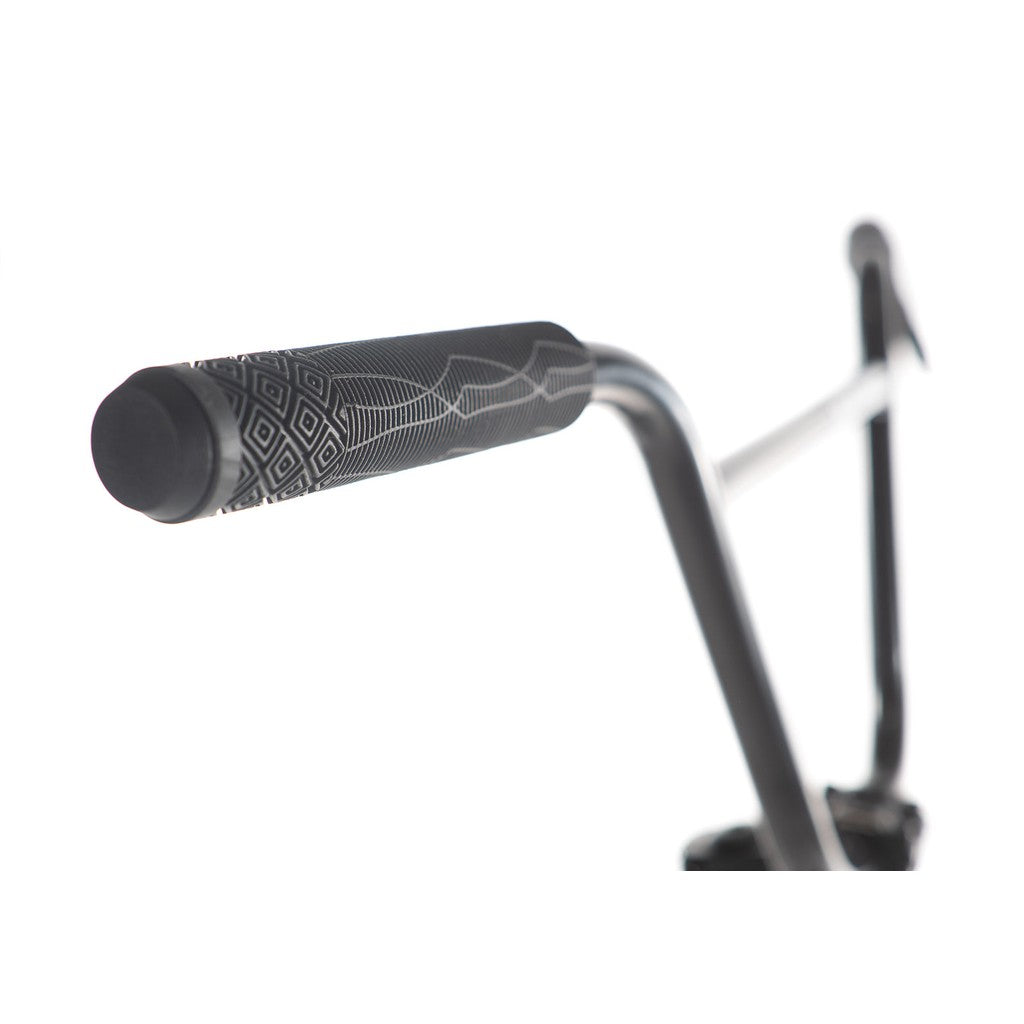 Close-up of a black handlebar grip with geometric patterns on the Academy Aspire 20 Inch Bike, featuring sleek CrMo bars on a silver handlebar against a white background.