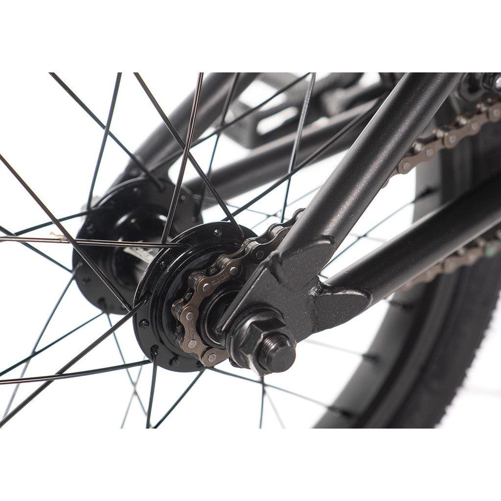 Close-up of an Academy Inspire 16 Inch Bike wheel highlighting its sealed hubs, double wall rims, spokes, chain, and a section of the frame in a sleek black finish.