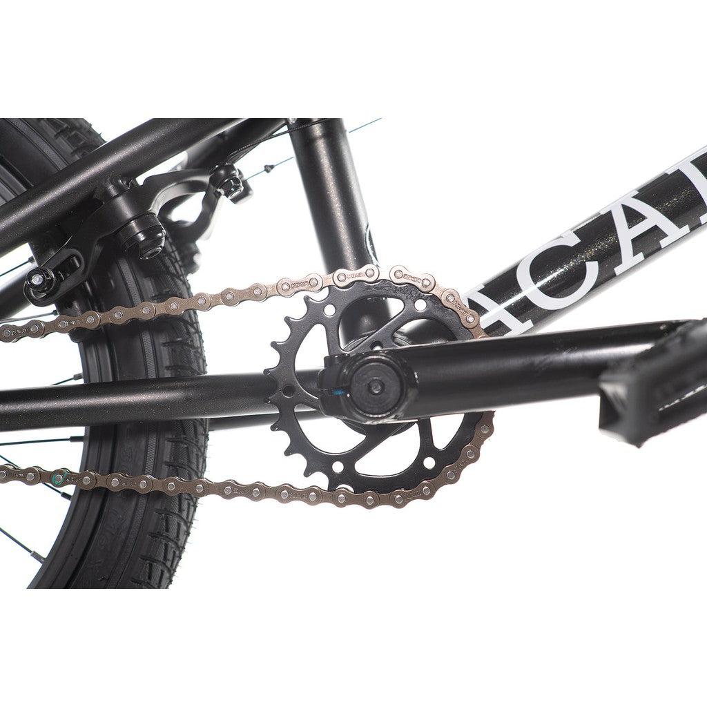 Close-up of the Academy Inspire 16 Inch Bike's drivetrain, highlighting the chain, sprocket, and part of the frame, improved by sealed hubs for enhanced performance.