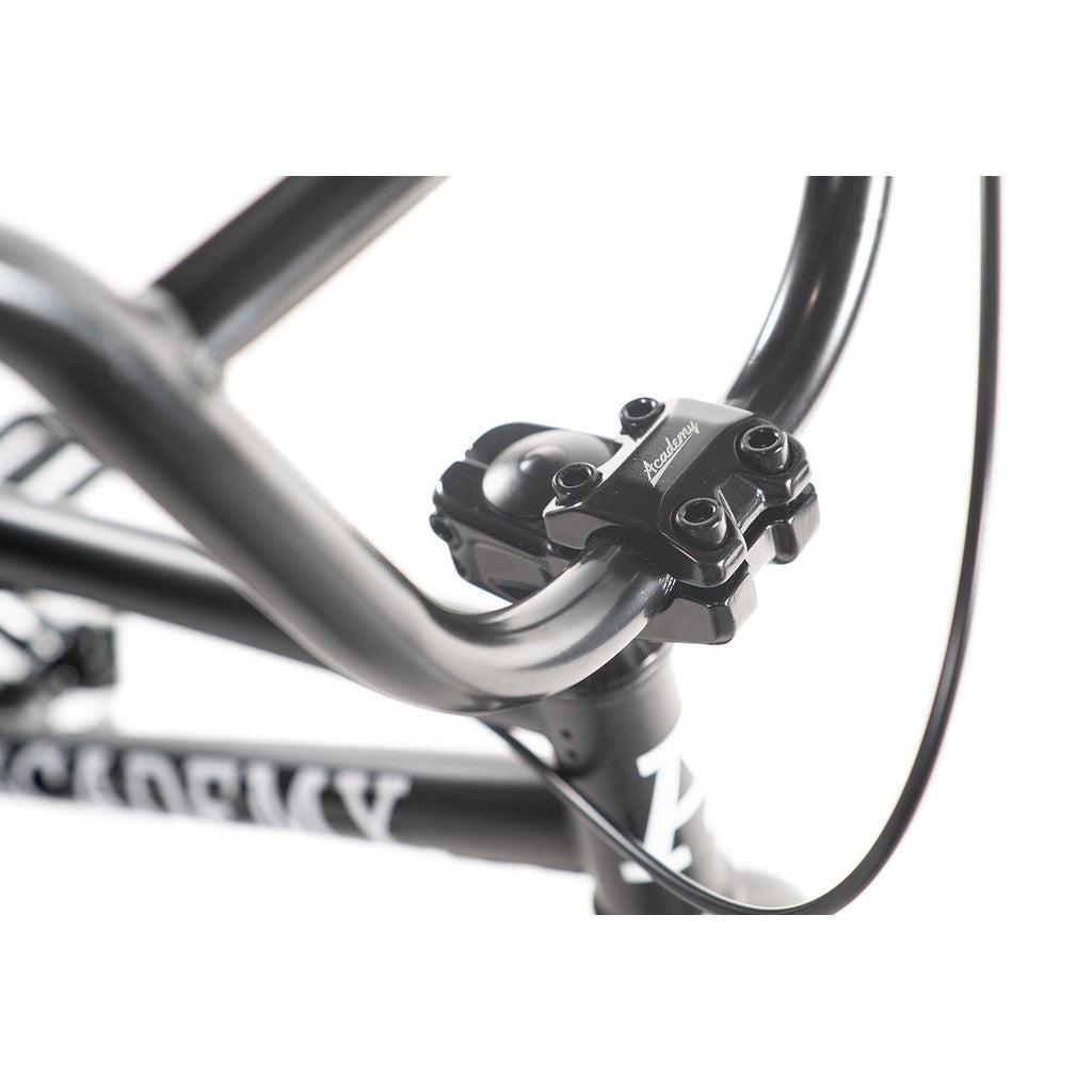 Close-up of the handlebars and stem of the Academy Inspire 16 Inch Bike against a white background, highlighting its sleek design and impressive attention to detail.