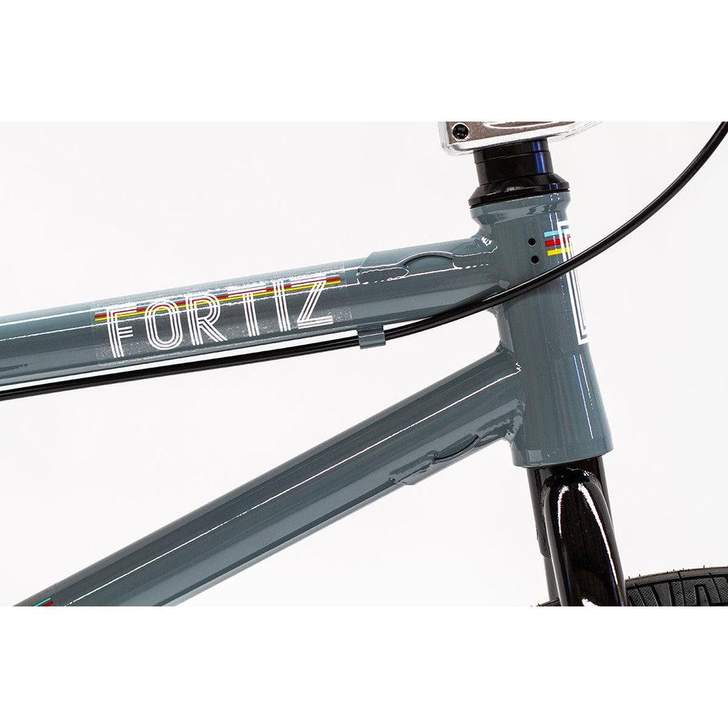 Close-up view of a grey Division Fortiz 20 Inch Bike featuring the brand name "FORTIZ" printed on its Chromoly frame.