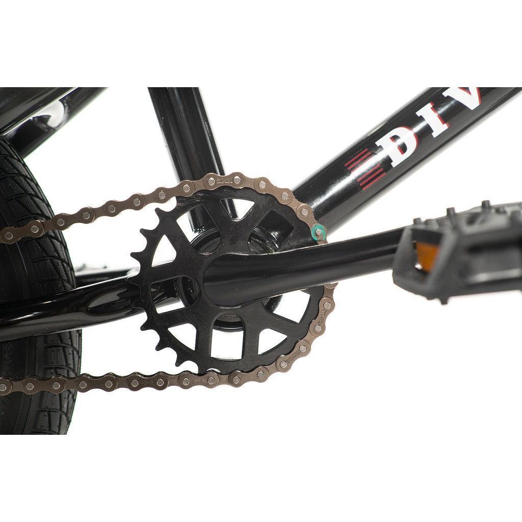 Close-up view of a black bicycle chain and sprocket on the Division Blitzer 14 Inch Bike, an entry-level freestyle BMX, with a portion of the frame and pedal visible.